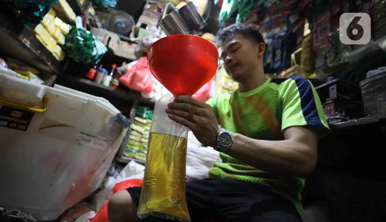 Pedagang tengah mengemas minyak curah di Pasar Kebayoran Lama, Jakarta, Jumat (15/7/2022). Berdasarkan Sistem Pemantauan Pasar Kebutuhan Pokok (SP2KP) Kementerian Perdagangan, harga minyak goreng curah hari ini, Jumat (15/7/2022) berada di level Rp15.200 per liter secara nasional. Harga ini tercatat turun yakni Rp15.236 pada Kamis (14/7/2022). (Liputab6.com/Angga Yuniar)