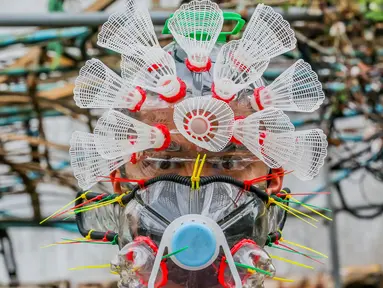 Seniman Filipina Leeroy New mengenakan masker improvisasi di studionya di Manila, 22 Mei 2020. Leeroy New menggunakan botol plastik daur ulang, gelas dan kok untuk membuat masker artistik COVID-19 yang juga akan tampilkan dalam pameran online bersama seniman visual lainnya. (Xinhua/Rouelle Umali)