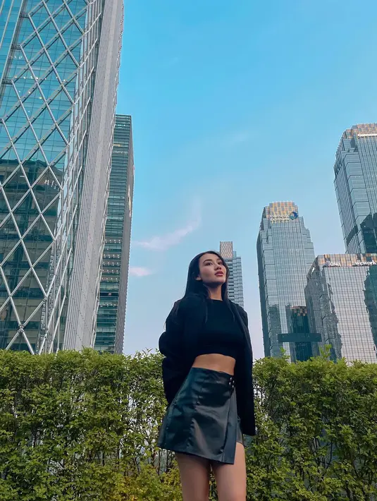 Dengan low angle, Aaliyah pamer body goals dengan gaya cewek mamba. Ia padukan croptop hitam dengan rok mini kulit dan blazer [@aaliyah.massaid]