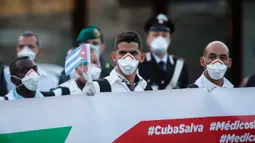 Petugas medis dan paramedis dari Kuba berpose setibanya di bandara Malpensa di Milan, Italia, Minggu (22/3/2020). Kedatangan tim medis Kuba membantu Italia mengendalikan pandemi virus Corona, salah satu negara terkaya di Eropa, merupakan yang pertama kali terjadi. (AP/Antonio Calanni)