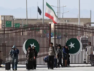 Warga Pakistan berjalan melintasi perbatasan Taftan, di provinsi Balochistan, Iran pada Selasa 3 Maret 2026, di tengah serangan Amerika Serikat dan Israel yang terus memanas. (Banaras KHAN/AFP)
