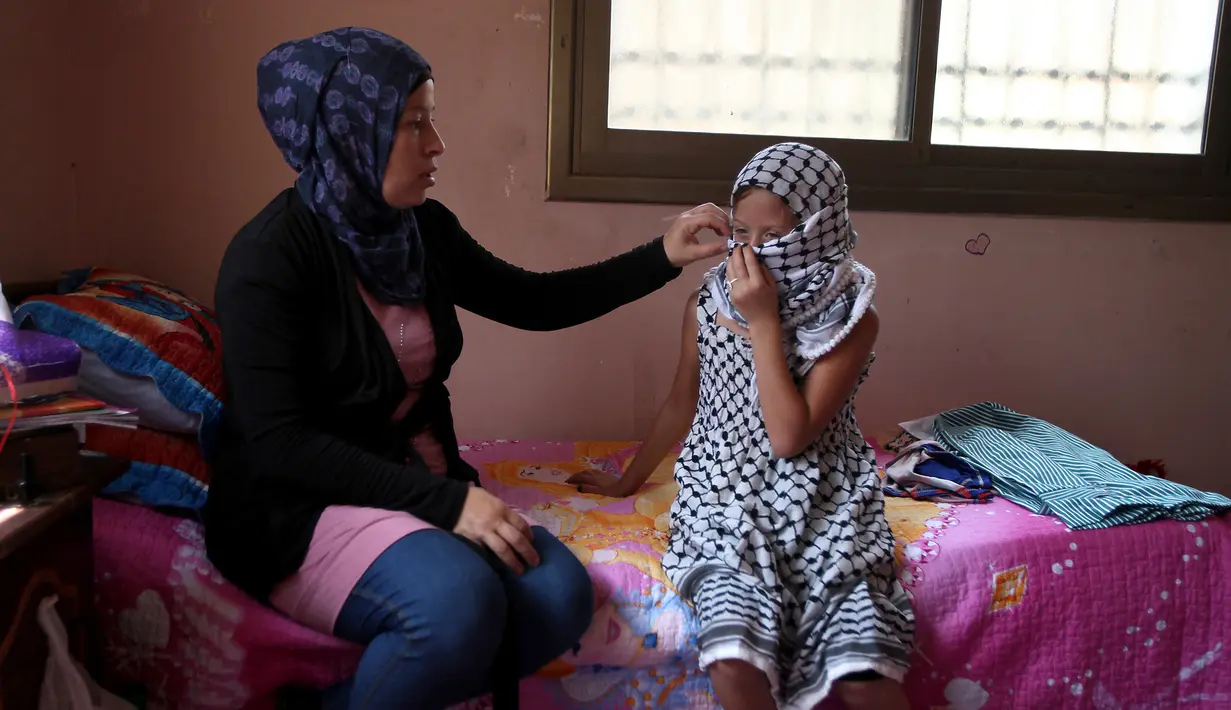 Foto yang diambil pada 31 Agustus 2012 menunjukkan Ahed Tamimi (kanan) bersama ibunya Nariman Tamimi bersiap untuk melakukan demonstrasi melawan pendudukan Israel di Desa Nabi Saleh. (AFP Photo/Abbas Momani)