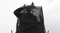 Patung Jendral Sudirman ditutup kain transparan hitam saat perawatan di Jakarta, Senin (16/4). Perbaikan Patung tersebut untuk merawat agar patung tetap dalam kondisi baik dan tidak terjadi korosi karena faktor cuaca. (Liputan6.com/Arya Manggala)