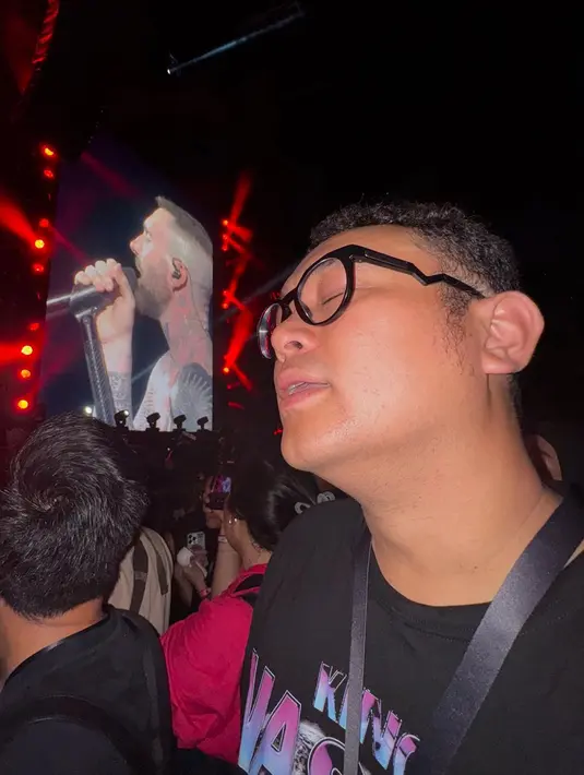 Adiezty sempat mengabadikan momen unik saat wajah Gilang tertangkap kamera dengan angle tertentu. Ketika layar konser menampilkan Adam Levine sedang bernyanyi, ia memotret wajah suaminya dan membandingkannya dengan sang vokalis. Ia pun bertanya kepada pengikutnya apakah keduanya terlihat mirip. (Liputan6.com/IG/@adieztyfersa)