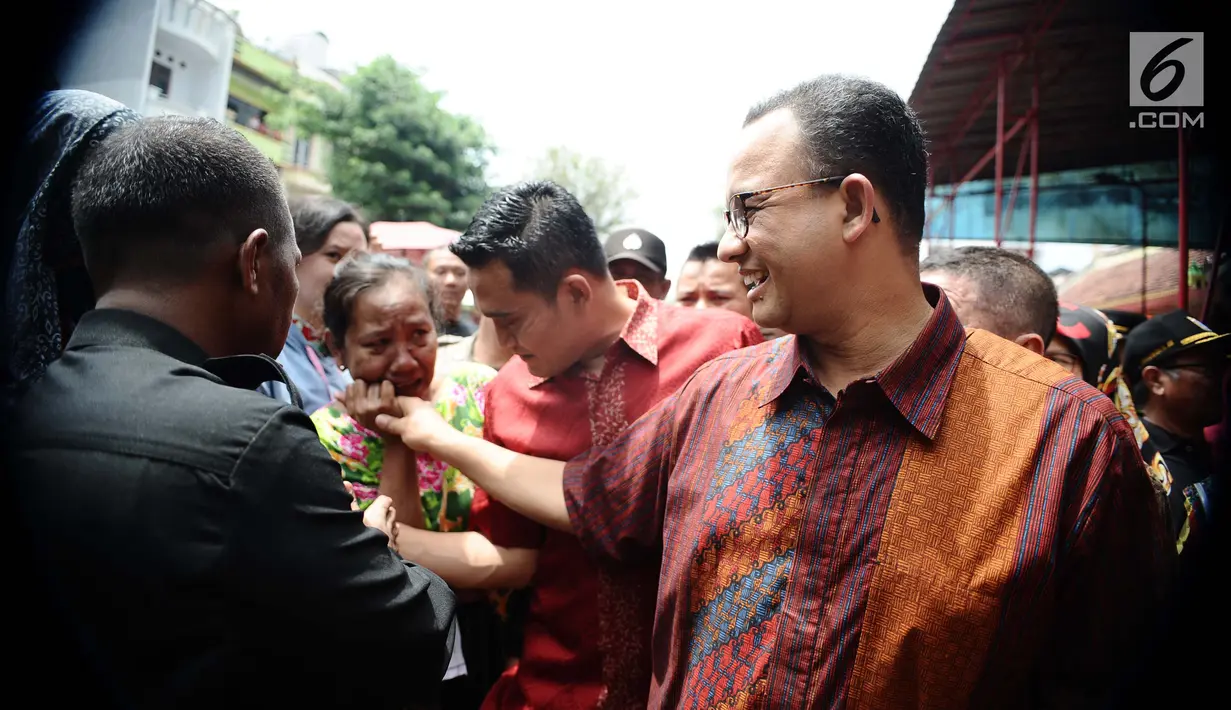 Gubernur DKI Jakarta Anies Baswedan menyemarakkan perayaan Imlek dengan mendatangi Vihara Dharma Bakti di kawasan Glodok, Jakarta Barat, Jumat (16/2). Dengan mengenakan batik, Anies didampingi anak ketiganya, yakni Kaisar. (Liputan6.com/Gempur M Surya)