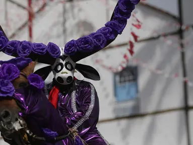 Seorang peserta mengenakan kostum menunggang kuda yang dihias saat mengikuti festival "Cavalhadas" di Pirenopolis, Brasil (20/5). Festival ini digelar selama tiga hari. (AP Photo/Eraldo Peres)