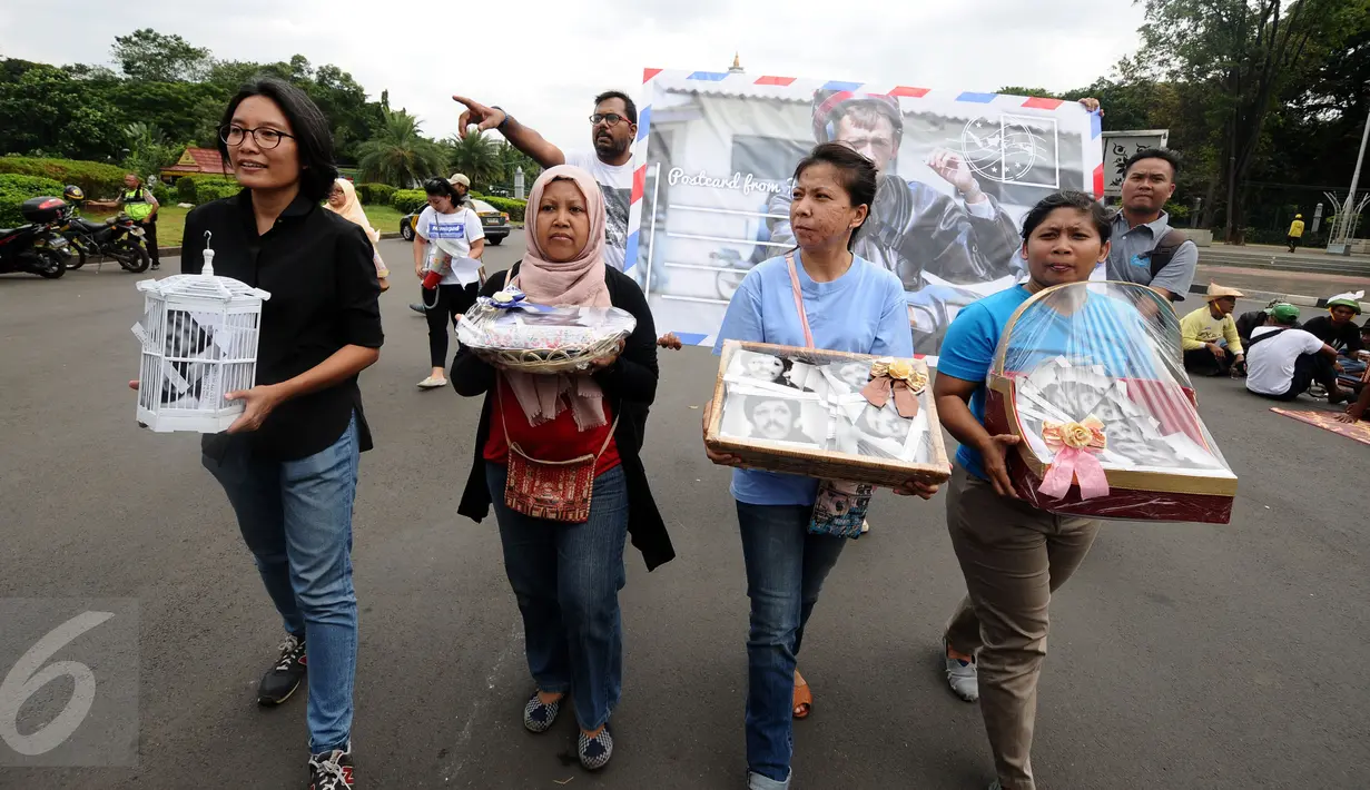 Aktivis KontraS berjalan menuju Sekretariat Negara untuk menyampaikan Kartu Pos Desak Presiden Selesaikan Kasus Munir, Jakarta, Selasa (17/1). Kartu dikumpulkan dari masyarakat di 20 kota di Indonesia. (Liputan6.com/Helmi Fithriansyah)