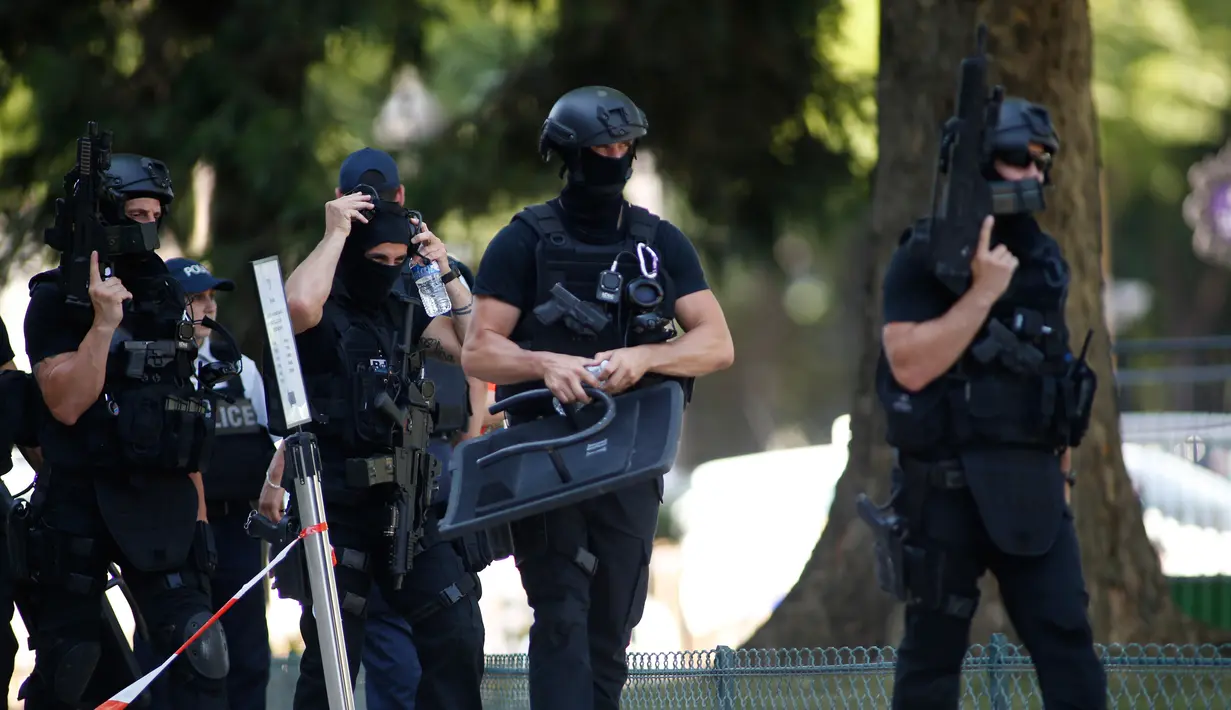 Polisi bersenjata melakukan patroli di kawasan Champs Elysees di Paris, Senin (19/6). Seorang pria yang dilengkapi senjata sengaja menabrakkan kendaraannya ke van milik polisi dan kemudian tewas di jalanan ikonik itu. (AP Photo/Matthieu Alexandre)