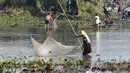 Penduduk desa menggunakan jaring ikan saat mengikuti acara memancing bersama dalam perayaan panen Bhogali Bihu di Danau Goroimari di Panbari, Assam, India, pada 14 Januari 2020. “Bhogali Bihu” menandai berakhirnya musim panen di bagian timur laut negara bagian Assam. (Xinhua/Str)