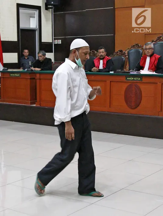 Ekspresi terdakwa kasus penembakan dr Letty Sultri, dr Helmi saat memasuki ruang sidang PN Jakarta Timur, Kamis (29/3). Sejumlah keluarga dan teman korban menghadiri sidang tersebut. (Liputan6.com/Herman Zakharia)