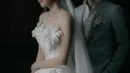 Shanju mengenakan gaun pernikahan strapless yang memiliki aksen bunga-bunga putih di bagian dada. Sementara itu, Jonatan tampil gagah dengan setelan jas abu-abu. [@elsiechrysila]