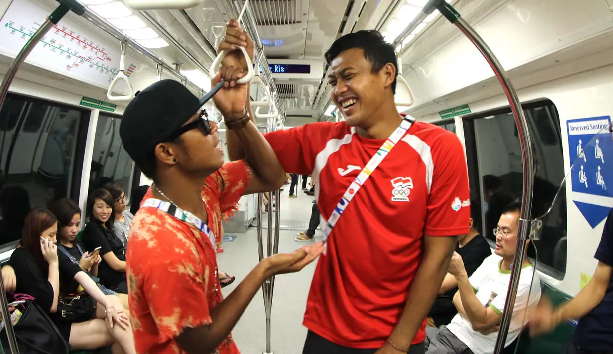 Manahati Lestusen dan M. Natshir Fadhil bercanda saat naik MRT. (Bola.com/Arief Bagus)