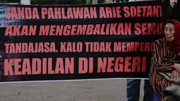 Janda veteran, Ibu Arie Soetanto menggelar aksi untuk mengembalikan tujuh tanda jasa kepahlawanan suaminya, Arie Soetanto (eks TNI Brigade XVII Tentara Pelajar) kepada negara melalui Presiden Jokowi di depan Istana Negara, Jakarta, Selasa (9/12/2014). (Li