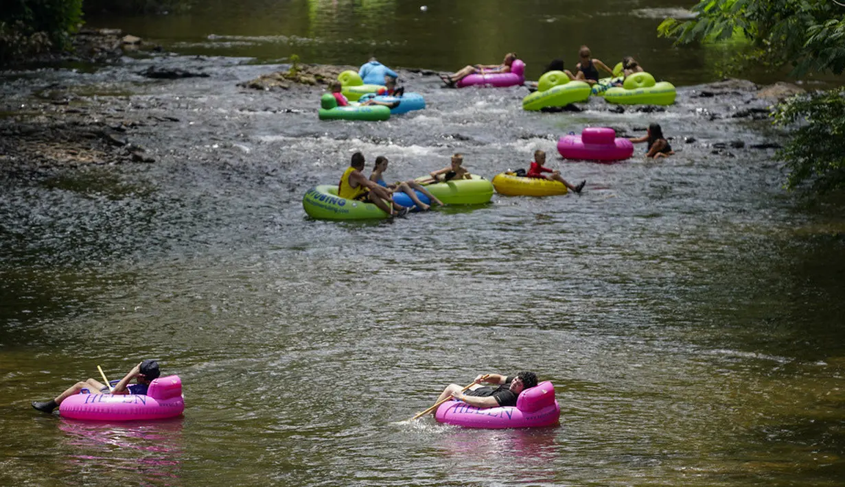 <p>Orang-orang menaiki ban di Sungai Chattahoochee, Helen, Georgia, 13 Juli 2023. (AP Photo/Mike Stewart)</p>