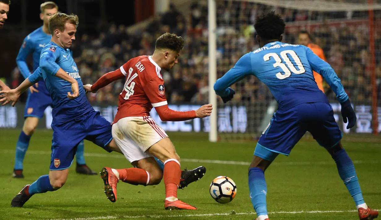 Gelandang Nottingham Forest, Matty Cash, berusaha melewati pemain Arsenal pada laga Piala FA di Stadion City Ground, Minggu (7/1/2018). Arsenal takluk 2-4 dari Nottingham Forest. (AFP/Oli Scarff)
