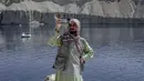 Seorang pria mengambil video dengan ponselnya di sebelah Danau Band e-Amir, Provinsi Bamiyan, 4 Oktober 2021. Danau Band-e Amir yang memiliki perairan biru menakjubkan disebut juga sebagai Grand Canyon Afghanistan. (BULENT KILIC/AFP)