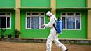 Seorang anggota Badan Penanggulangan Bencana Daerah (BPBD) menyiapkan disinfektan untuk disemprotkan di sebuah Sekolah Menengah Pertama (SMP) dalam rangka program mitigasi pencegahan penyebaran flu burung di Banda Aceh pada Jumat 31 Oktober 2025. Menurut Sukmawati, ini murni langkah pencegahan, bukan karena ada kasus. (Chaideer MAHYUDDIN/AFP)
