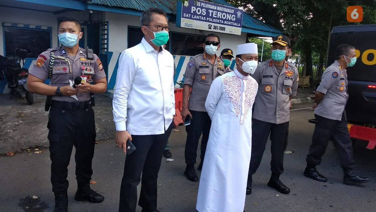 Polisi dan pemuka agama memberi imbauan agar warga terapkan social distancing (Fauzan/Liputan6.com)