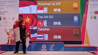 Lifter asal Aceh, Muhammad Zul Ilmi, berhasil mempersembahkan medali emas SEA Games 2021 untuk Indonesia dari cabang olahraga angkat besi di nomor 89 kg men's di Hanoi Sports Training and Competition Center, Hanoi, Minggu (22/5/2022) siang waktu setempat. (Bola.com/Muhammad Adiyaksa)
