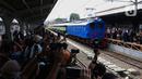 Warga menyaksikan rangkaian lokomotif listrik ESS 3200 tahun pembuatan 1927 saat memasuki peron pada perayaan 100 tahun operasional Kereta Rel Listrik (KRL) di Stasiun Jakarta Kota, Selasa (22/4/2025). (Liputan6.com/Angga Yuniar)