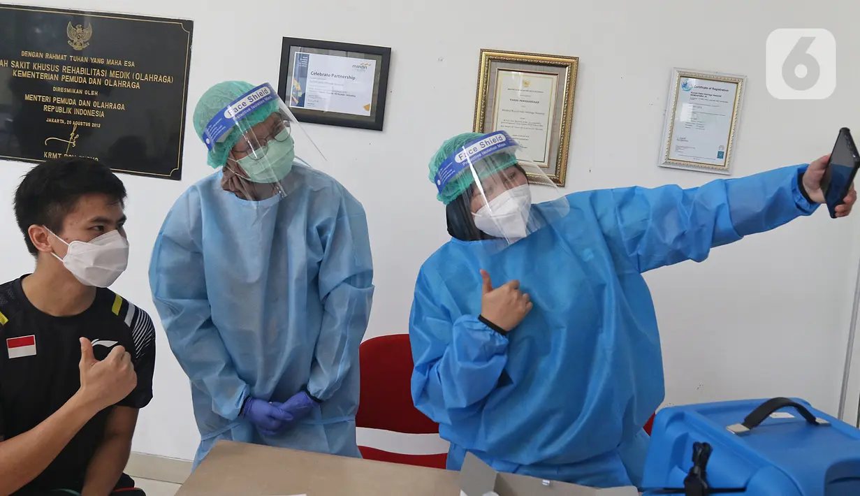 Petugas medis berselfie dengan Atlet Wushu Edgar Xavier Marvelo di Rumah Sakit Olahraga Nasional, Jakarta, Jumat (12/3/2021). Kemenpora bersama Kemenkes melakukan vaksinasi COVID-19 dosis ke-2 kepada insan olah raga nasional dengan menyasar 820 orang secara bertahap. (Liputan6.com/Herman Zakharia)