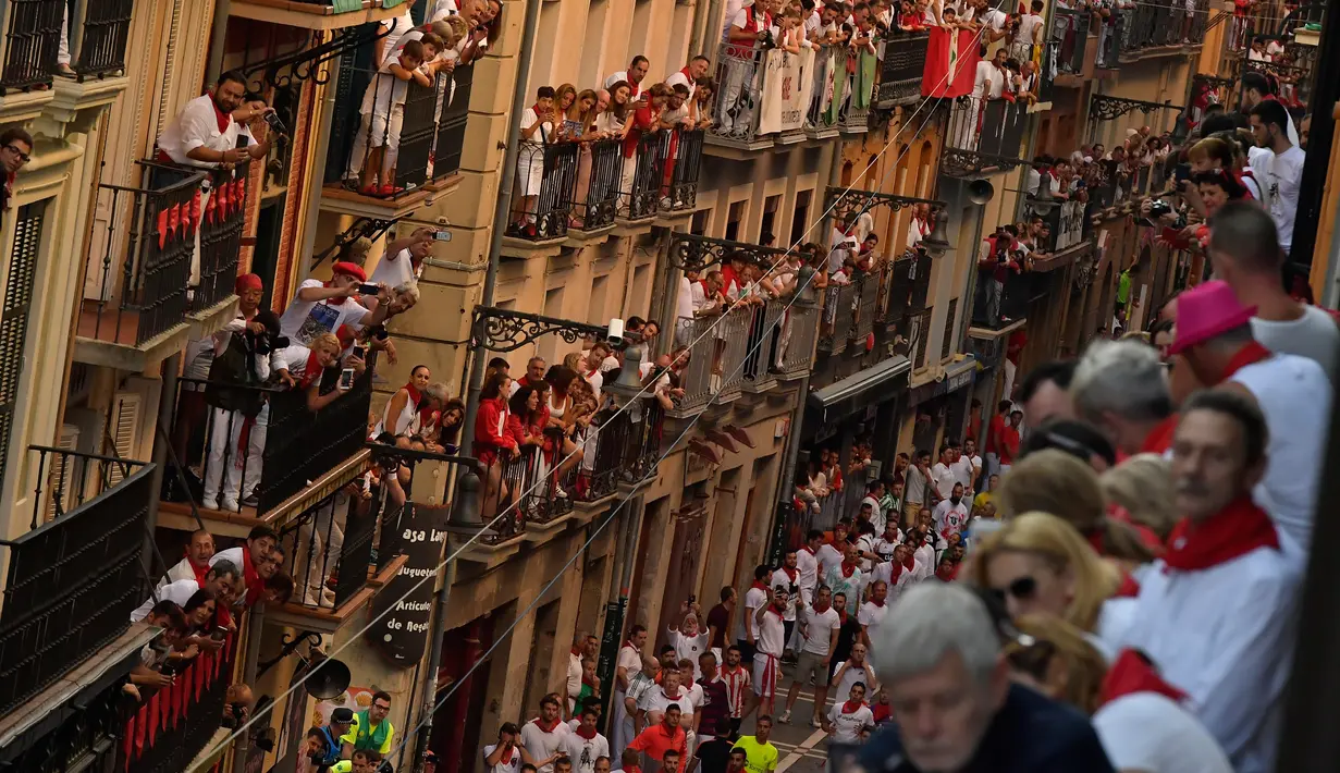Orang-orang berdiri di balkon saat menunggu dimulainya Festival San Fermin di Pamplona, Spanyol, Senin (9/7). (AP Photo/Alvaro Barrientos)
