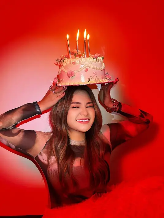 Nathalie pamer foto cantik dan estetik dengan kue ulang tahun. Latar belakang merah mendominasi sesi foto tersebut. [Instagram.com/nathalieholscher]