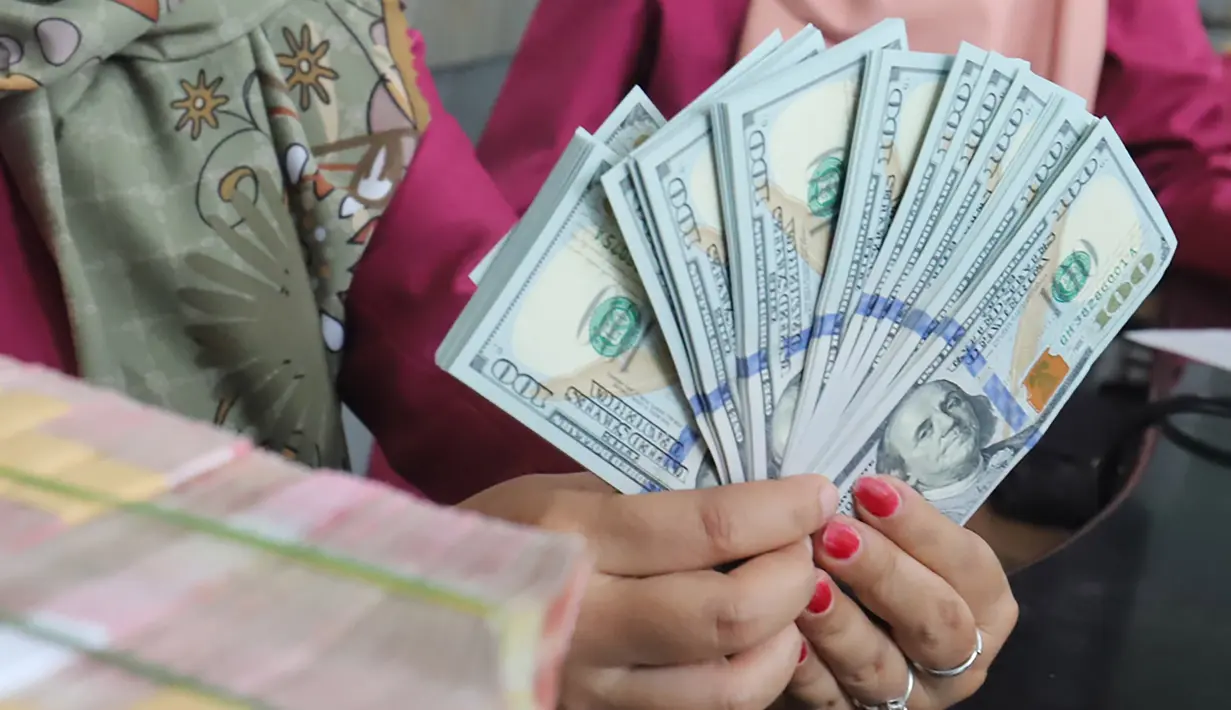 Karyawan menunjukkan lembaran uang Dolar AS dan Rupiah di VIP Money Changer, Jakarta, Jumat (5/6/2026). (merdeka.com/Arie Basuki)