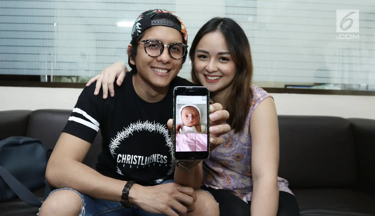 Pasangan Joanna Alexandra dan Raditya menunjukkan foto anak ke 4 nya, Jakarta, Selasa (30/5). Joanna melahirkan anak ke empat yang diberi nama Ziona Eden Alexandra Panggabean. (Liputan6.com/Herman Zakharia)