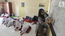 Siswa kelas VI  Madrasah Ibtidaiyah Mathlaul Anwar Ciangsana melakukan proses belajar mengajar tanpa meja dan kursi pada bangunan majelis taklim di Tenjolaya, Bogor, Selasa(22/10/2019).  Kegiatan itu dilakukan karena dua dari lima ruang kelas yang ada sudah rusak dan lapuk. (merdeka.com/Arie Basuki)