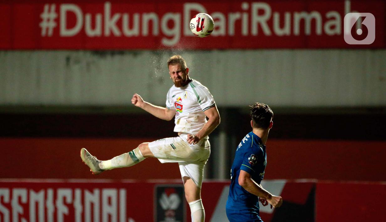 Pemain PS Sleman Maslac Mario menyundul bola dibayangi pemain Persib Bandung,  Nick Kuipers (kanan) dalam pertandingan semifinal leg pertama Piala Menpora 2021 di Stadion Maguwoharjo, Sleman, Jumat (16/4/2021). Kemenangan itu menjadi modal Persib menghadapi leg kedua. (Bola.com/Ikhwan Yanuar)