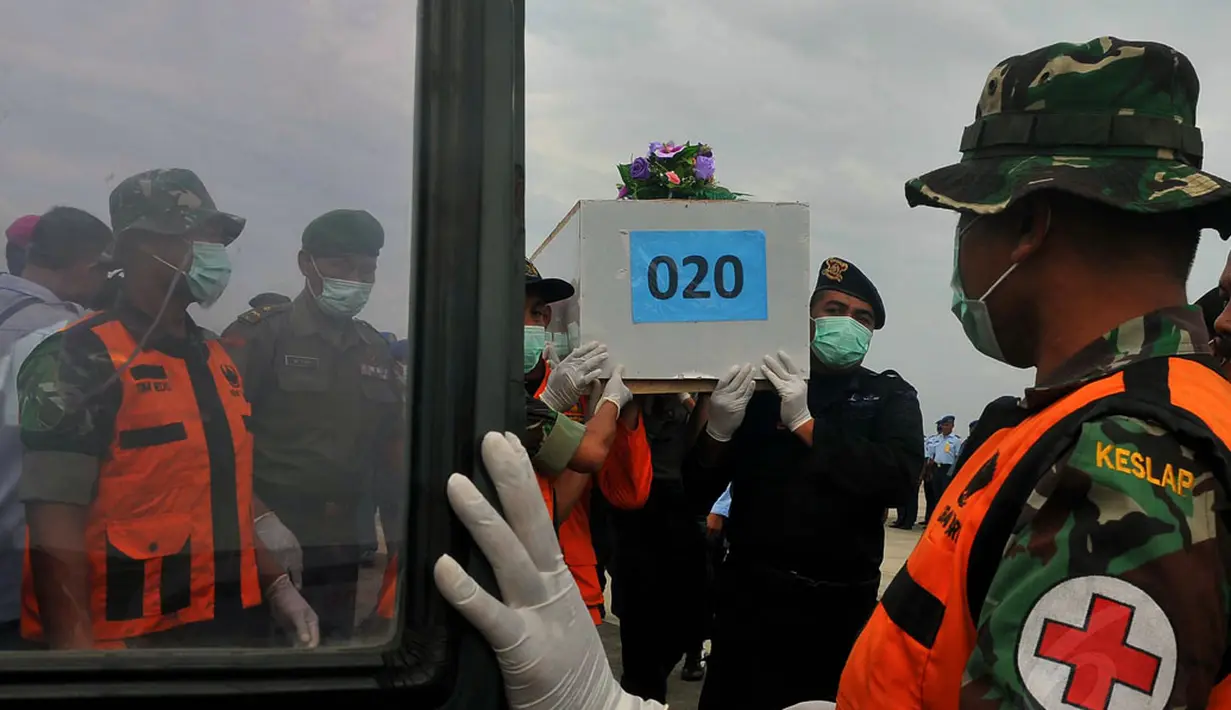 Tim SAR gabungan kembali menerima 12 jenazah korban pesawat AirAsia QZ8501 di Lanud TNI AL Juanda, Surabaya, Sabtu (3/1/2015). Tampak jenazah bernomor peti 020 siap dimasukkan ke dalam ambulans. (Liputan6.com/Johan Tallo)
