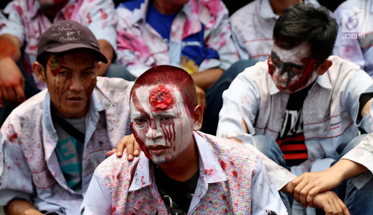 Massa buruh awak mobil tangki (AMT) berdandan seperti zombi melakukan aksi di depan gedung Pertamina, Jakarta, Senin (23/10). Mereka juga meminta bertemu dengan Presiden Joko Widodo (Jokowi) untuk mendengarkan tuntutan mereka. (Liputan6.com/Angga Yuniar)