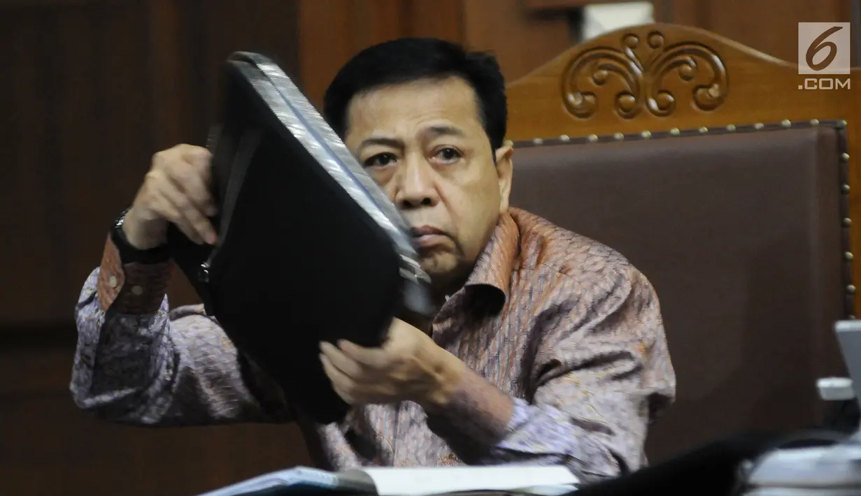 Terdakwa dugaan korupsi proyek e-KTP Setya Novanto mengangkat berkas saat mengikuti sidang lanjutan di Pengadilan Tipikor, Jakarta, Senin (15/1). Sidang bergaendakan mendengar keterangan saksi. (Liputan6.com/Helmi Fithriansyah)