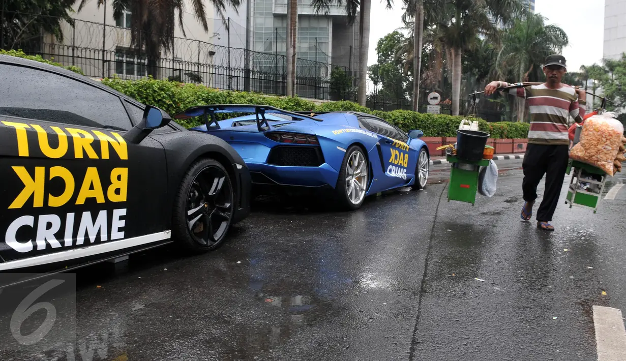 Dua Lamborghini terparkir di kawasan Bundaran HI saat Car Free day, Jakarta, Minggu  (29/11/2015). Dua Lamboghini ini sengaja parkir untuk kampanye memerangi kejahatan karena di Ibukota. (Liputan6.com/Johan Tallo)