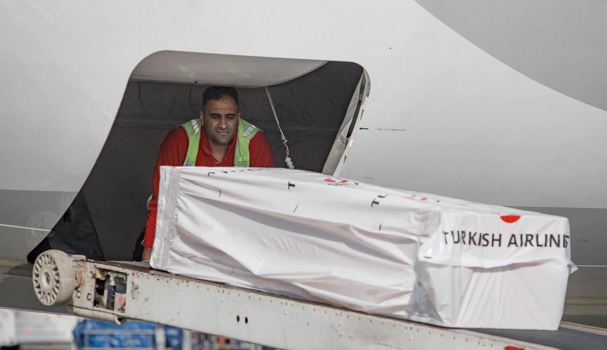 Jenazah mantan pemain sepak bola internasional Ghana Christian Atsu dimuat ke pesawat menuju Ghana, di bandara Adana di selatan Turki, 18 Februari 2023. Atsu, 31, terjebak dalam gempa berkekuatan 7,8 yang mengguncang Turki dan Suriah pada 6 Februari, menewaskan lebih dari 43.000 orang di kedua negara. (AFP/Can Erok)