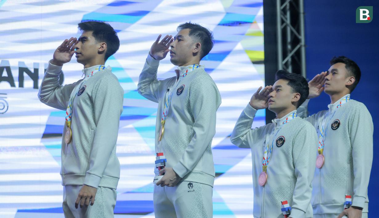 Ganda putra Indonesia Sabar Karyaman Gutama/Moh. Reza Pahlevi Isfahani bersama Leo Rolly Carnando/Bagas Maulana menyanyikan lagu Indonesia Raya di atas podium setelah berhasil meraih medali SEA Games 2025. (Bola.com/Bagaskara Lazuardi)