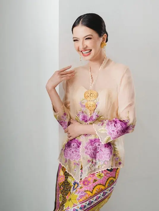 Raline Shah tampil dengan kebaya pastel bercorak floral dipadukan bros keemasan serasi dengan anting. Dipadukan kain batik warna colorful. [@ralineshah]