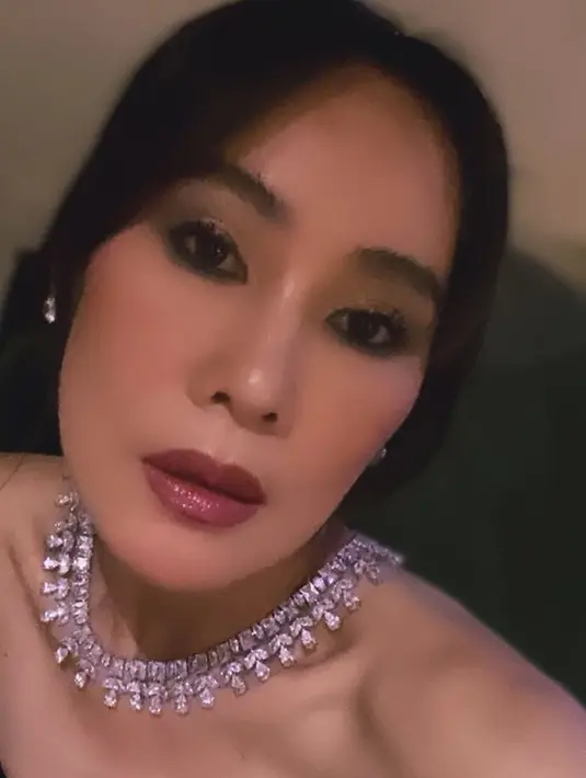Wajahnya dipoles makeup glam, dengan mengaplikasikan blush on pink dan bibirnya dipoles lipstik glossy maroon. Matanya dihiasi eyeshadow coklat shimmer. Rambut panjangnya dibiarkan terurai indah. [@inathomas]