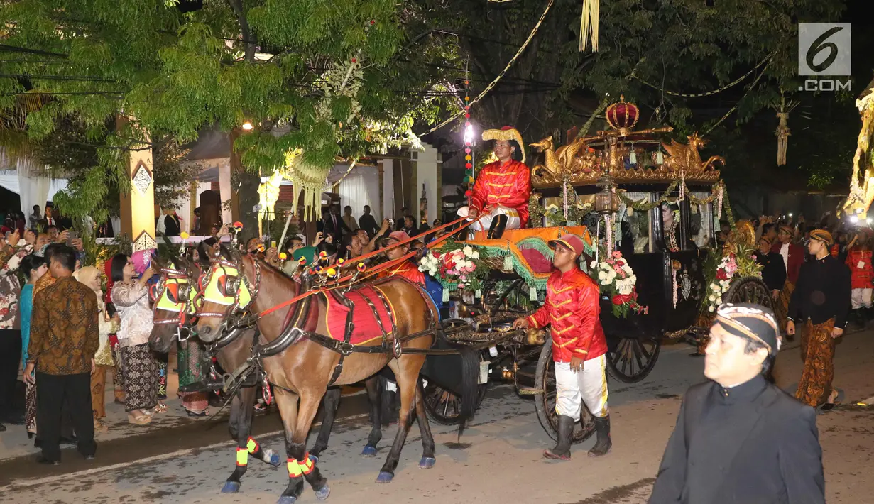 Kereta kencana membawa pasangan pengantin Kahiyang Ayu dan Bobby Nasution menuju Graha Saba Buana, Solo, Rabu (8/11). Kahiyang dan Bobby menaiki kereta kencana saat resepsi pernikahan malam. (Liputan.com/Angga Yuniar)