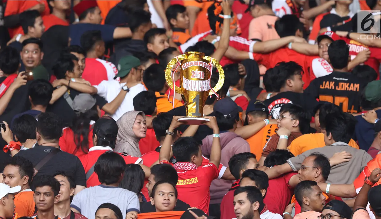 Suporter tim Macan Kemayoran bersorak merayakan gelar juara Go-Jek Liga 1 Indonesia 2018 bersama Bukalapak yang diraih Persija di Stadion GBK, Jakarta, Minggu (9/12). Persija meraih gelar juara dengan 62 poin. (Liputan6.com/Helmi Fithriansyah)