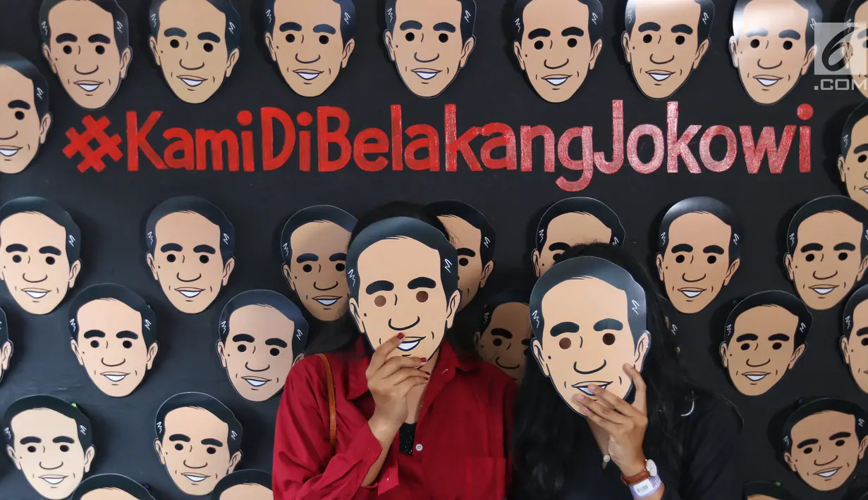 Dua pendukung calon Presiden no urut 01 Joko Widodo berpose mengenakan topeng berwajah Jokowi di Istora Senayan, Jakarta, Minggu (10/3). Acara Festival Satu Indonesia dibuka Presiden Jokowi. (Liputan6.com/Johan Tallo)