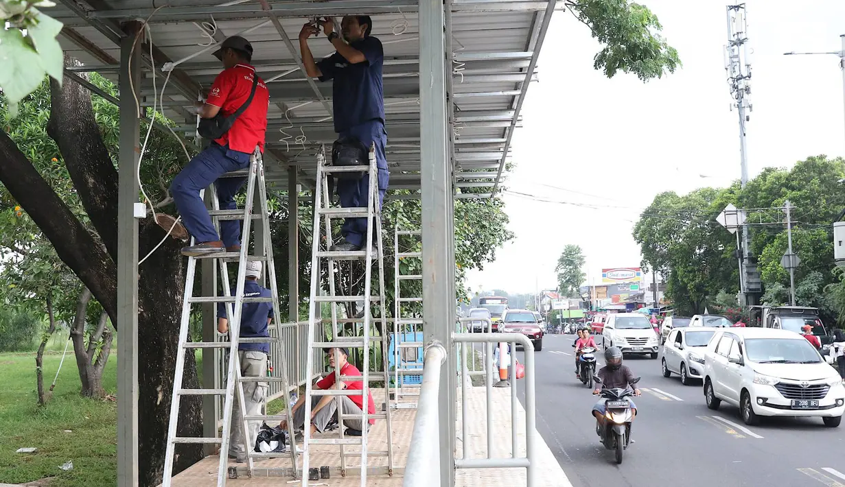 Pekerja menyelesaikan pembuatan halte Transjakarta di kawasan Kampung Rambutan, Jakarta, Jumat (1/3). Pembuatan halte tersebut bertujuan mempermudah warga untuk mengakses bus Transjakarta. (Liputan6.com/Immanuel Antonius)
