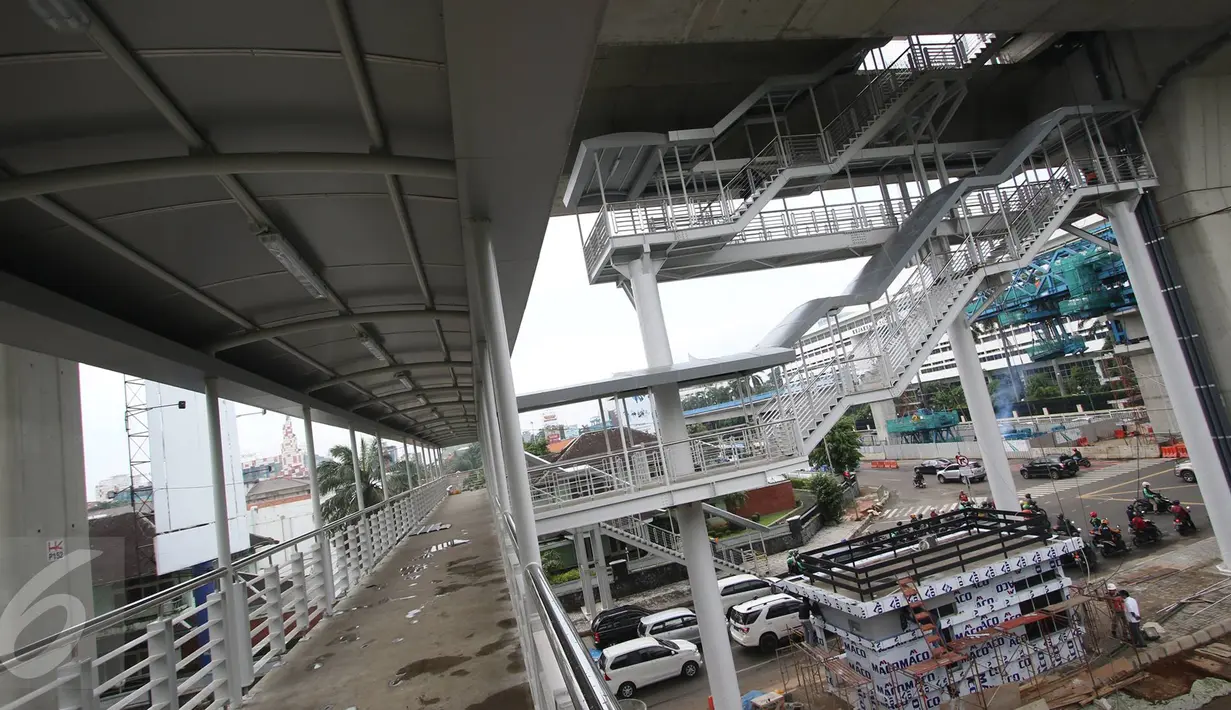 Sejumlah kendaraan melintas di bawah pembangunan Jembatan Penyeberangan Orang (JPO) halte layangTransjakarta CSW di Kebayoran Baru, Jakarta, Senin (9/1). JPO halte ini setara dengan bangunan empat lantai. (Liputan6.com/Immanuel Antonius)