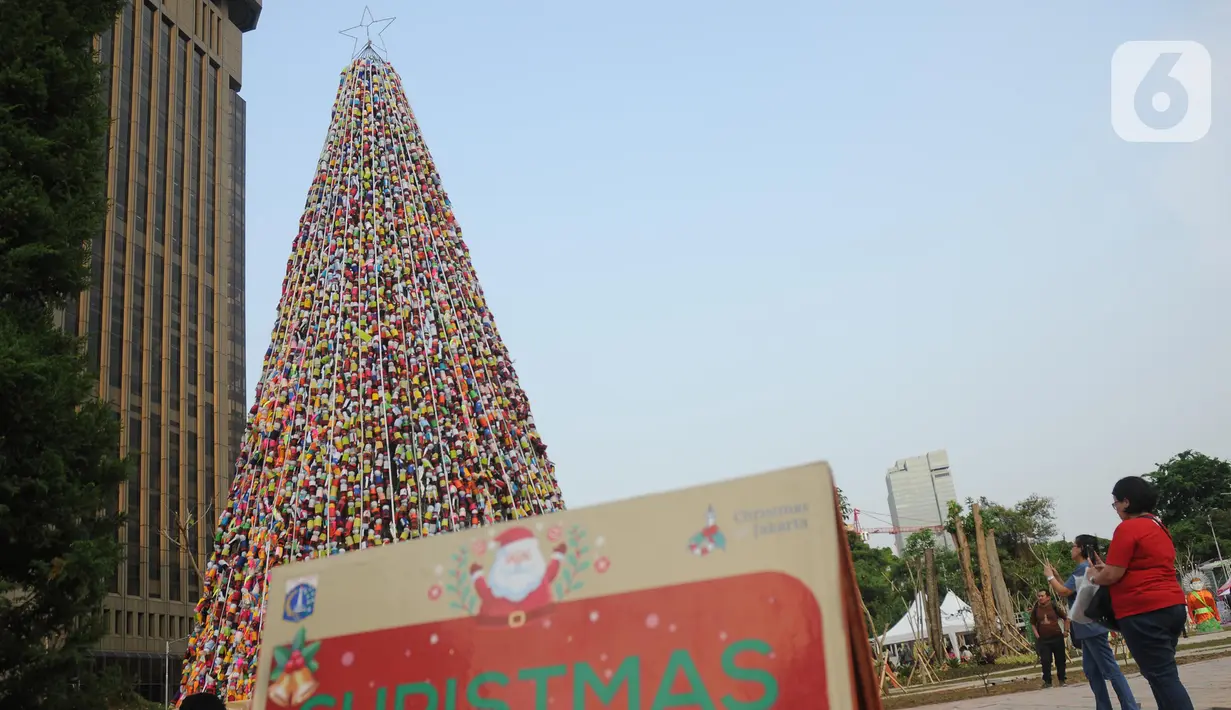 Warga melihat pohon Natal dari miniatur ondel-ondel yang terbuat dari botol minuman bekas di Food Court Thamrin 10, Jakarta, Sabtu (21/12/2019). Sekitar 8.000 botol air mineral bekas dihias dan dirangkai menyerupai Pohon Natal yang bisa disaksikan oleh masyarakat. (Liputan6.com/Helmi Fithriansyah)