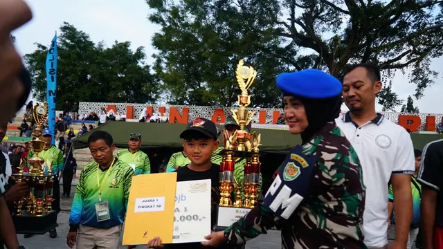 Dandenpom III/2 Garut, Letkol CPM (K) Wiana Warsanah memberikan piala penghargaan juara 1 lomba baris berbaris tingkat SMA sederajat. (Liputan6.com/Jayadi Supriadin)