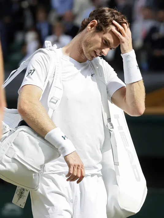 Andy Murray memegang hanya tertunduk saat keluar dari arena usai kalah dari Sam Querrey pada laga tunggal putra Wimbledon Tennis Championships 2017 di London, (12/7/2017). (AP/Kirsty Wigglesworth)