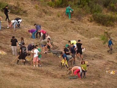 Orang-orang melakukan pekerjaan pembersihan hutan pegunungan di Taman Nasional Picos de Europa, di kota Riano, Provinsi Leon, Spanyol, pada 18 Agustus 2025. (CESAR MANSO/AFP)