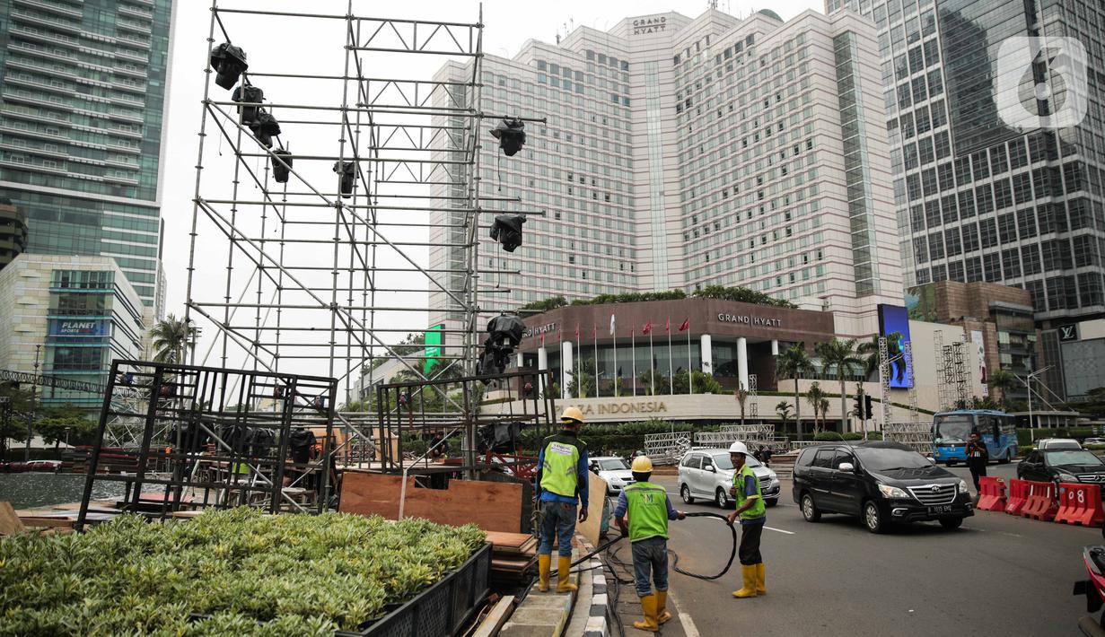 Pekerja memasang panggung untuk acara malam tahun baru di sekitar kawasan Bundaran HI, Jakarta, Rabu (25/12/2019). Merayakan pergantian tahun, Pemprov DKI Jakarta menggelar sejumlah acara di sejumlah titik sepanjang Jalan Sudirman-MH Thamrin. (Liputan6.com/Faizal Fanani)