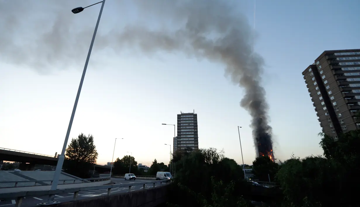 Pemandangan dari jauh gedung apartemen bertingkat 27 lantai yang terbakar di London (14/6). Pernyataan dari kepala pemadam kebakaran, api telah menjalar dari lantai dua hingga paling atas. (AP Photo/Matt Dunham)